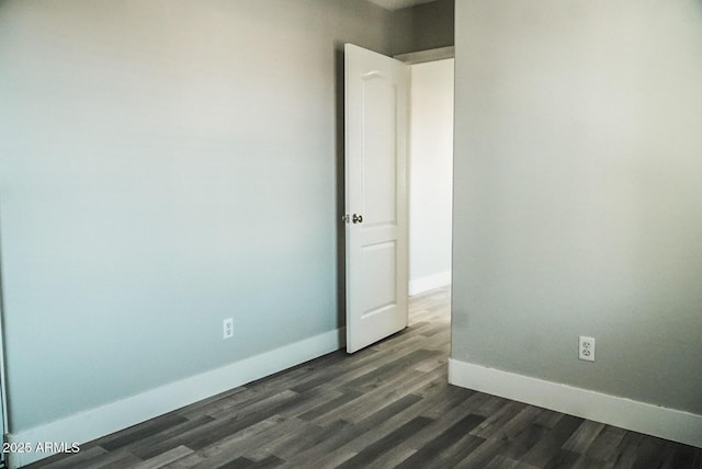 unfurnished room with dark wood-type flooring