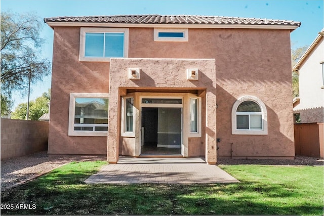 back of property featuring a patio and a lawn