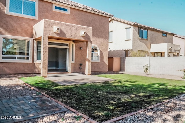 rear view of property featuring a patio and a lawn