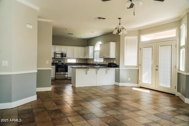 kitchen featuring a breakfast bar area, white cabinetry, hanging light fixtures, appliances with stainless steel finishes, and kitchen peninsula