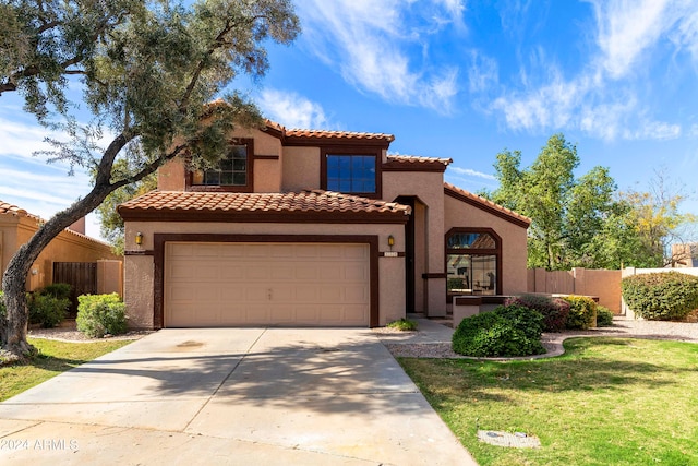 mediterranean / spanish-style house with a tiled roof, fence, driveway, and stucco siding