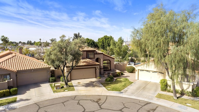 mediterranean / spanish-style home with a tiled roof, a residential view, concrete driveway, and stucco siding