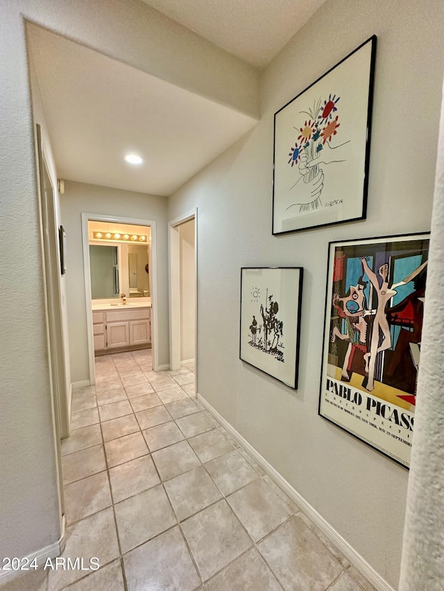 hall featuring light tile patterned floors and sink