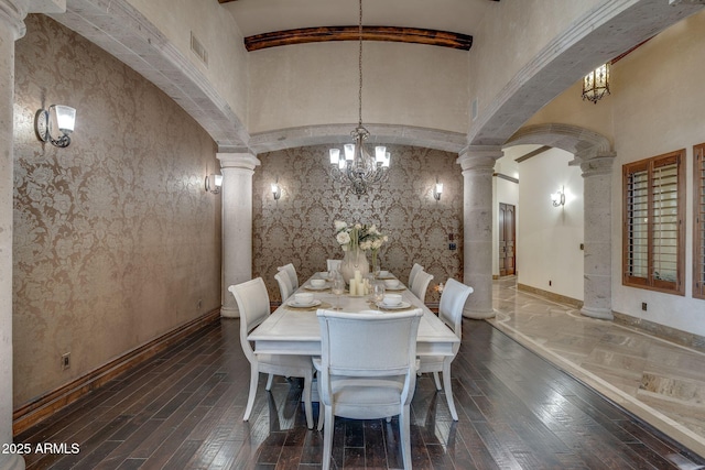 dining space with ornate columns and a notable chandelier