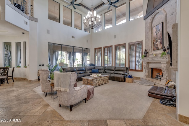 living room with a towering ceiling, a large fireplace, a notable chandelier, beam ceiling, and coffered ceiling