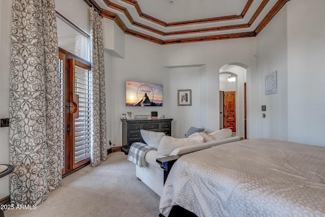 bedroom featuring light colored carpet, ornamental molding, and a towering ceiling