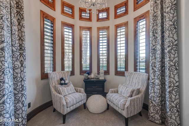 living area with an inviting chandelier and carpet floors