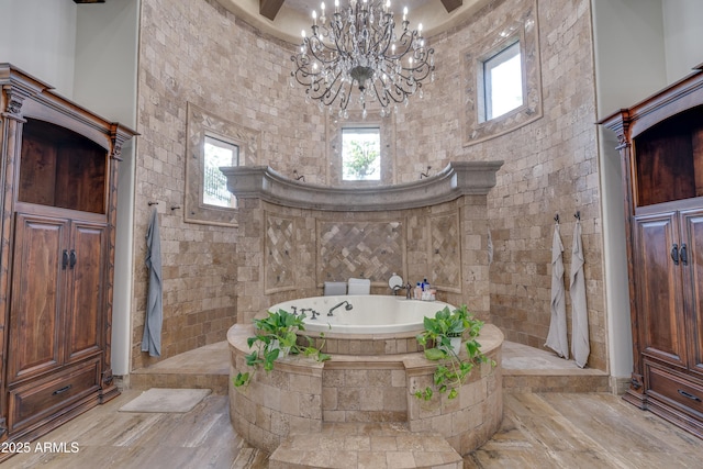 bathroom with shower with separate bathtub, a high ceiling, and a notable chandelier