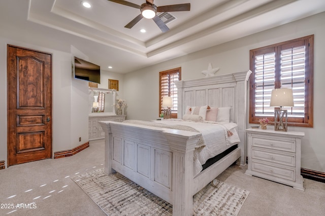 bedroom featuring ceiling fan, a raised ceiling, and light carpet