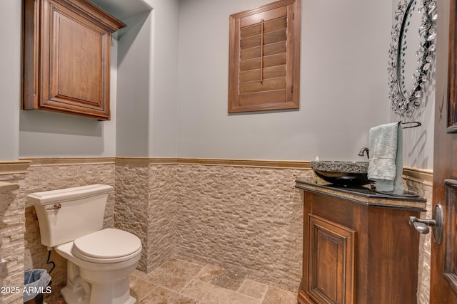 bathroom featuring tile walls, toilet, and vanity