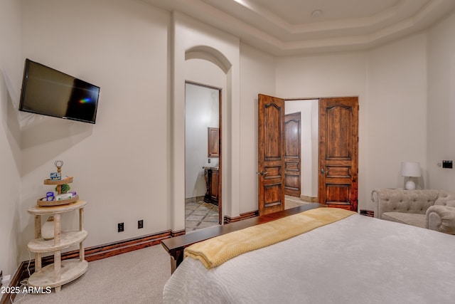 bedroom featuring a raised ceiling and a towering ceiling