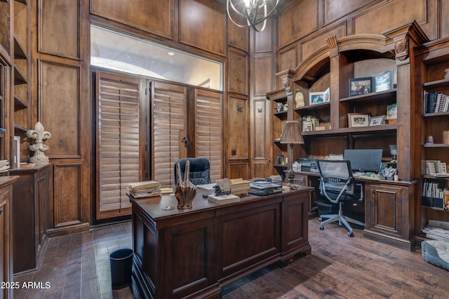 office space with wood walls, dark hardwood / wood-style floors, and a notable chandelier