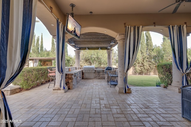 view of patio featuring ceiling fan, an outdoor kitchen, and grilling area