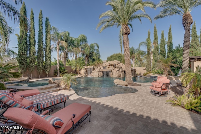 view of pool with an in ground hot tub, a patio area, and pool water feature