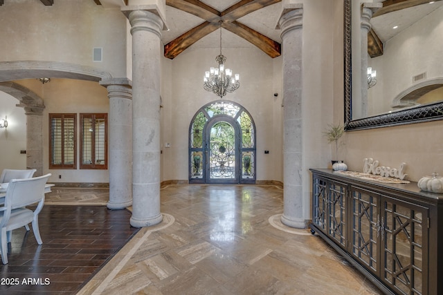 entryway with a chandelier, beam ceiling, french doors, and decorative columns