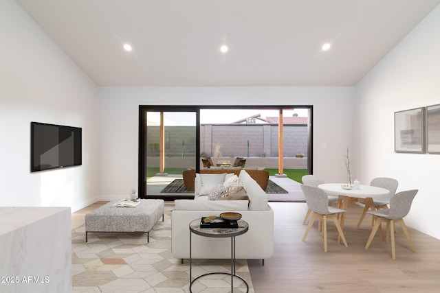 living room featuring lofted ceiling, light wood-style flooring, and recessed lighting