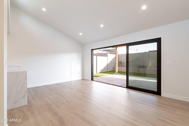 empty room featuring lofted ceiling, baseboards, light wood-style flooring, and recessed lighting