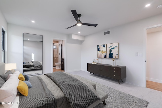 bedroom with recessed lighting, visible vents, ensuite bathroom, light carpet, and baseboards