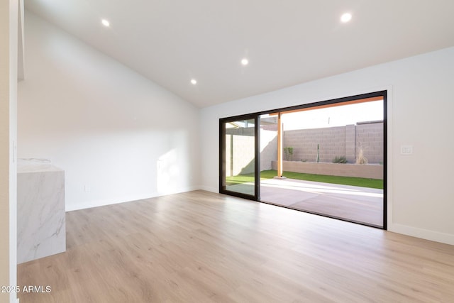 unfurnished room with lofted ceiling, baseboards, wood finished floors, and recessed lighting