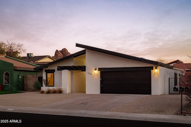 view of front of property featuring a garage, concrete driveway, and stucco siding