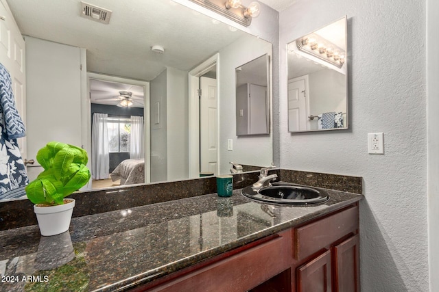 bathroom featuring a textured ceiling, vanity, and ceiling fan