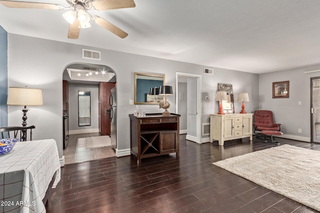 bedroom with stainless steel fridge, ceiling fan, and dark hardwood / wood-style floors