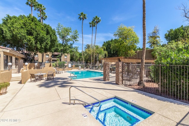 view of pool with a patio and a hot tub