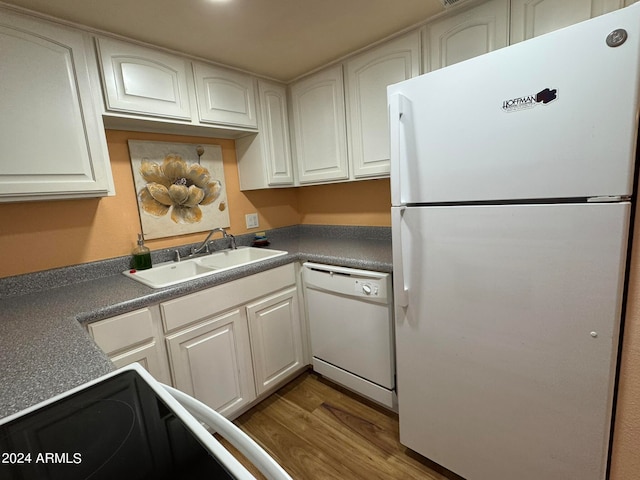 kitchen featuring white appliances, sink, dark wood-type flooring, and white cabinets