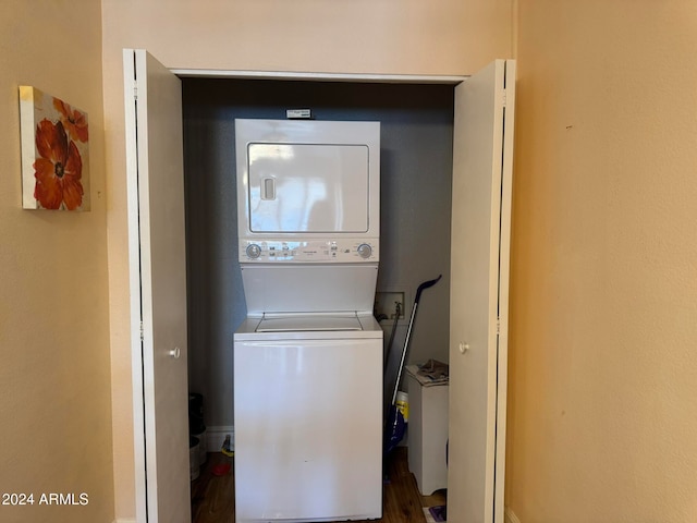 clothes washing area featuring stacked washer and clothes dryer and hardwood / wood-style flooring