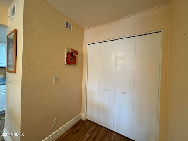 unfurnished bedroom with a closet and dark hardwood / wood-style flooring