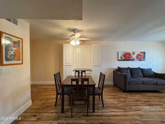 dining space featuring wood-type flooring and ceiling fan