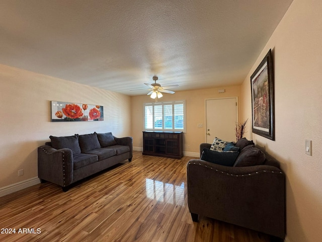 living room with ceiling fan, hardwood / wood-style flooring, and a textured ceiling