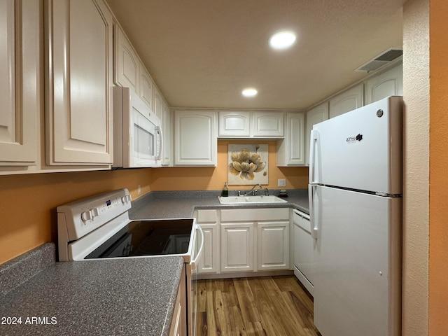 kitchen featuring light wood-type flooring, white appliances, white cabinetry, and sink