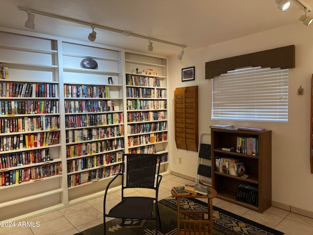 sitting room with track lighting and light tile patterned floors