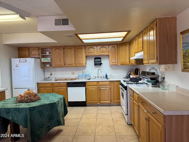 kitchen with light tile patterned flooring, sink, and white appliances