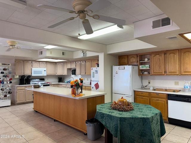 kitchen featuring white appliances, a kitchen island, and light tile patterned flooring