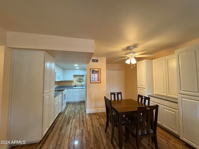 dining space featuring ceiling fan, dark hardwood / wood-style floors, and a textured ceiling