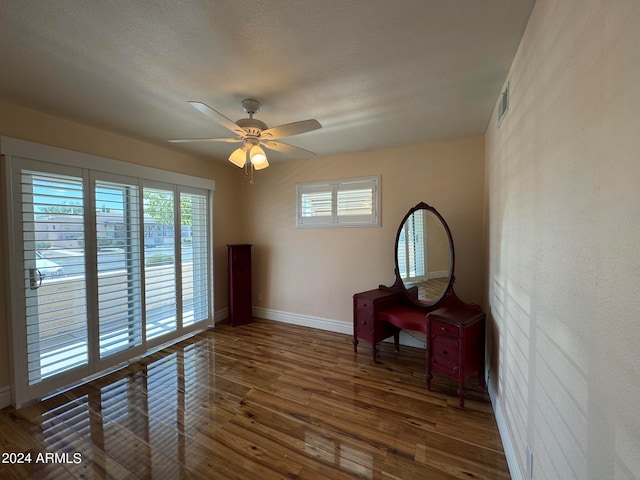 living area featuring ceiling fan, a textured ceiling, and dark wood-type flooring