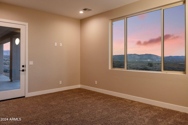 carpeted spare room featuring a mountain view and a wealth of natural light