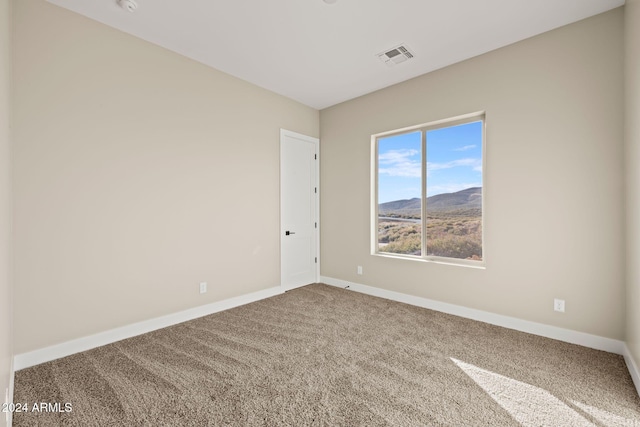 carpeted empty room featuring a mountain view