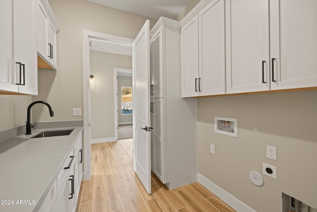 clothes washing area with hookup for an electric dryer, cabinets, sink, and hookup for a washing machine