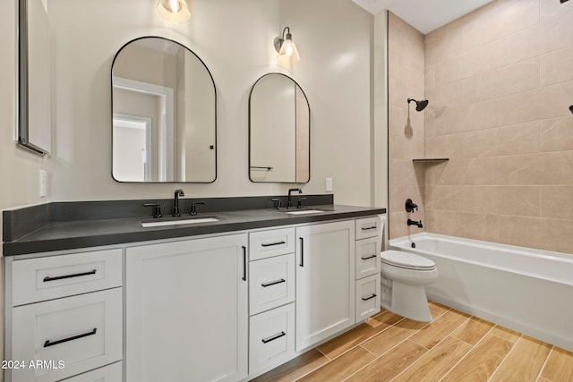 full bathroom featuring vanity, toilet, and tiled shower / bath