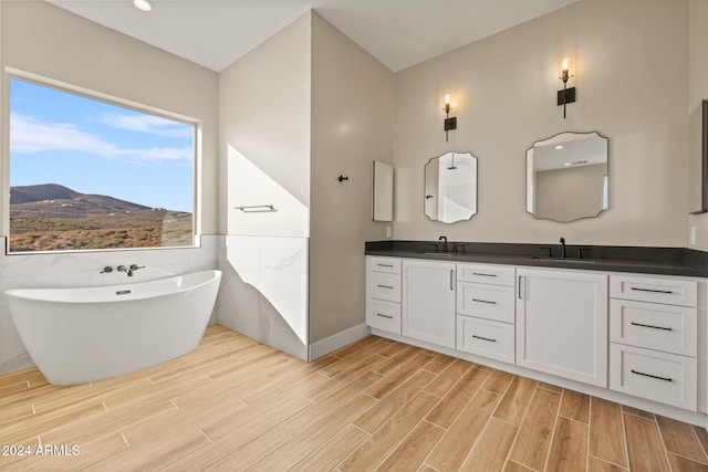 bathroom featuring a mountain view, a bath, vanity, and tile walls