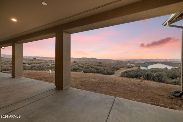 patio terrace at dusk featuring a mountain view