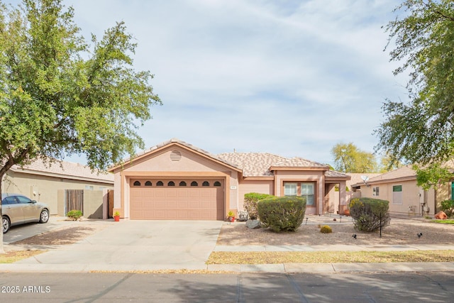 single story home featuring an attached garage, concrete driveway, and stucco siding