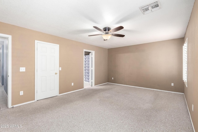 unfurnished bedroom featuring a ceiling fan, carpet, visible vents, and baseboards