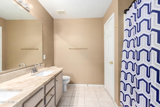 full bathroom featuring double vanity, visible vents, toilet, a sink, and tile patterned flooring