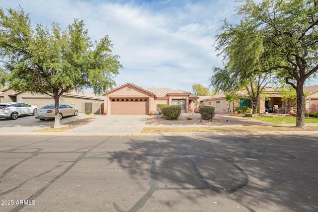 single story home featuring driveway, a garage, and stucco siding