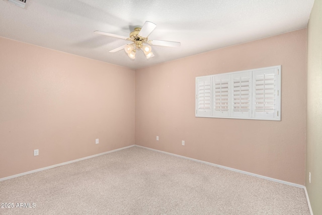 carpeted empty room featuring ceiling fan, a textured ceiling, and baseboards