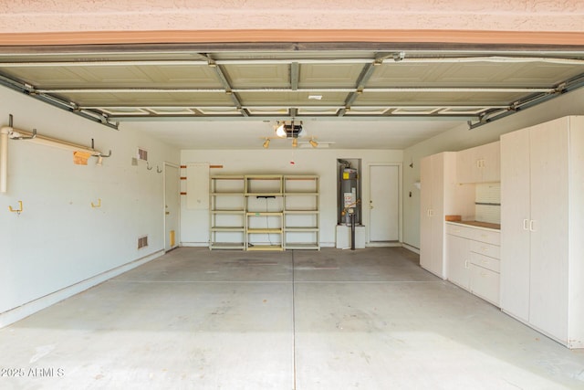 garage with secured water heater, visible vents, and a garage door opener